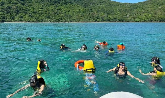 Du khách trải nghiệm trong làn nước biển xanh của Côn Đảo. Ảnh: VQG CĐ