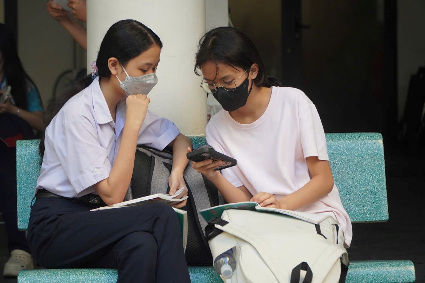 Một số thí sinh tranh thủ xem lại bài trước khi bước vào phòng thi. Ảnh: Chân Phúc