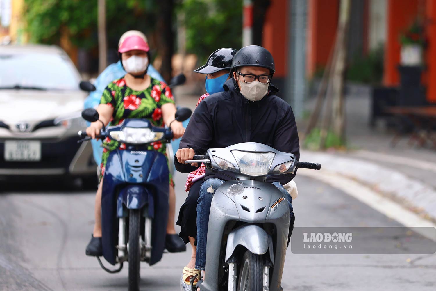 Nhieu nguoi di xe may “co ro” trong tiet troi se lanh giua mua he.