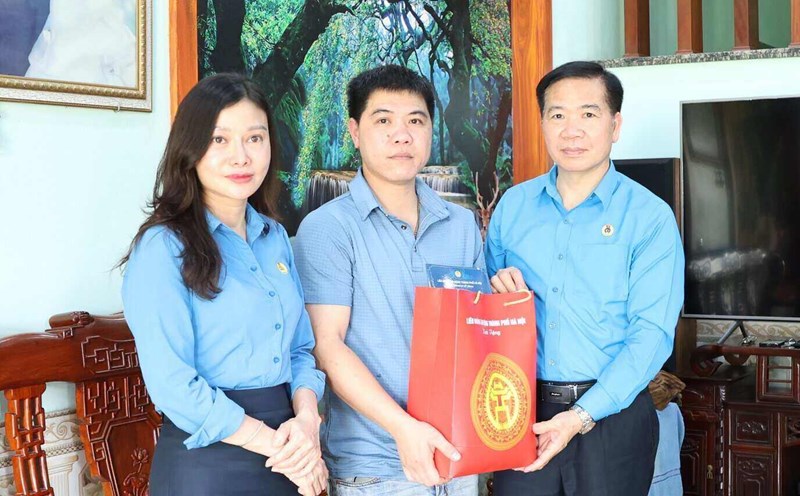 Vice President of the Hanoi City Labor Federation Nguyen Huy Khanh (far right) presented gifts to Mr. Hoang Xuan Loc - a worker who had a work accident with a disability rate of 51%. Photo: Manh Quan