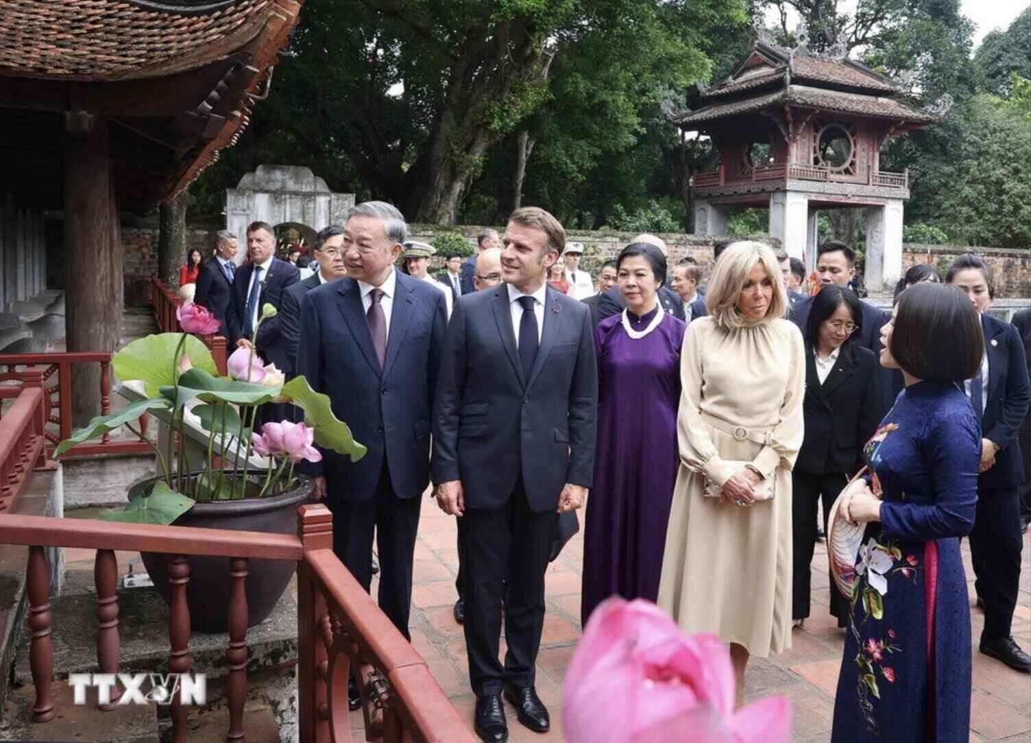 Tong Bi thu To Lam va Phu nhan cung Tong thong Phap Emmanuel Macron va Phu nhan nghe gioi thieu ve bia Tien si. Anh: TTXVN