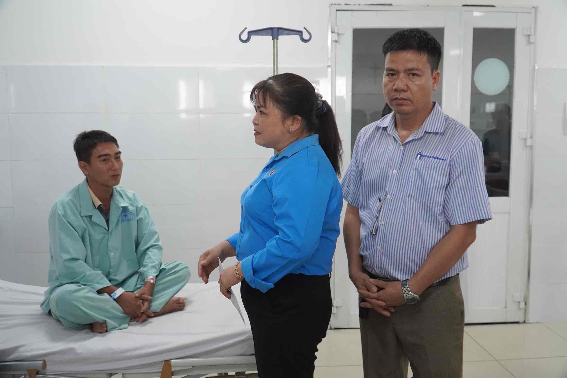 Chủ tịch LĐLĐ huyện Vĩnh Cửu Nguyễn Thị Minh Châu thăm hỏi công nhân Đặng Cao Hiến. Ảnh: HAC