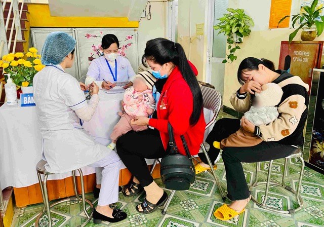 People take their children for vaccination at the commune health station. Photo: Thuy Linh