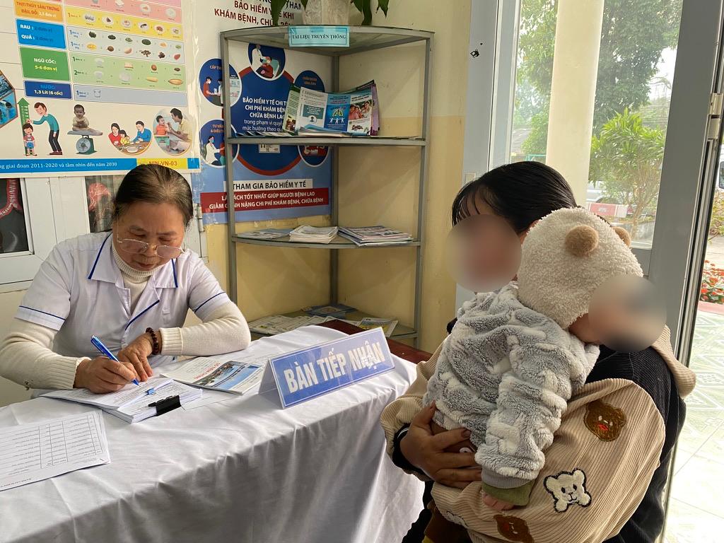 Can bo y te Tram y te xa o Dong Hy, Thai Nguyen don tiep nguoi dan dua con den tiem chung vaccine. Anh: Thuy Linh