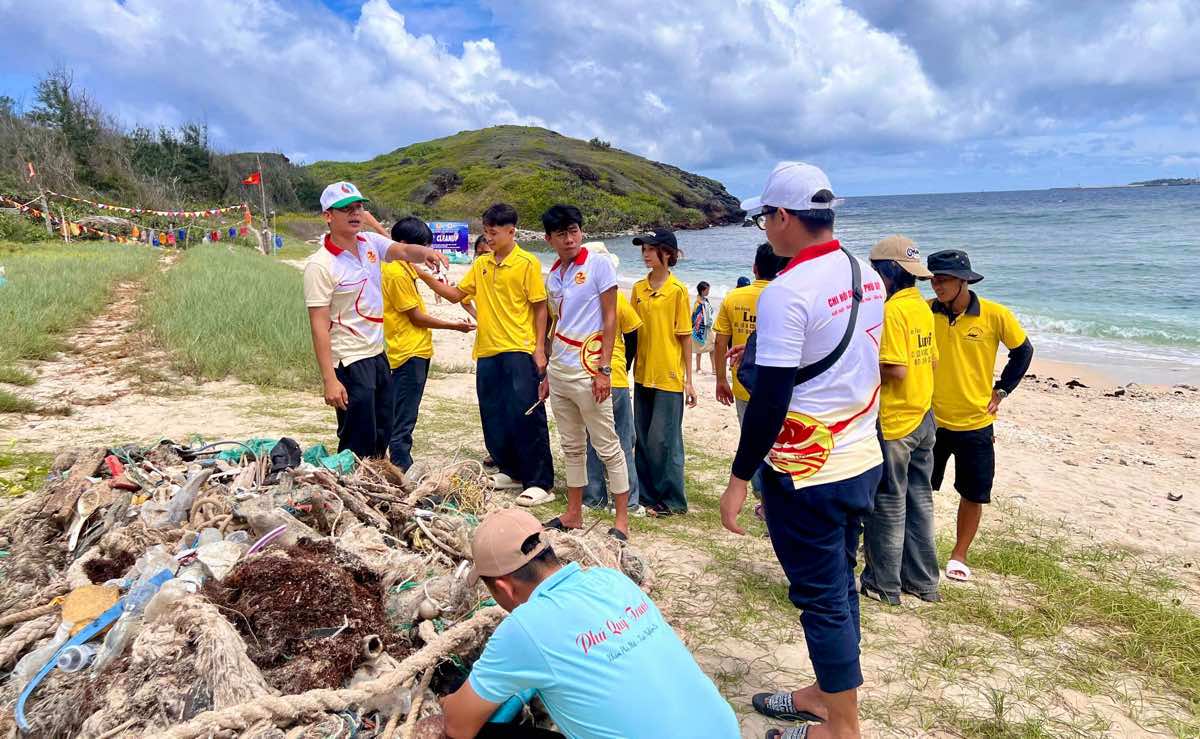 Cac tinh nguyen vien chia nhieu nhom nhat rac o nhieu vi tri bo bien Hon Tranh. Anh: Ngo Minh