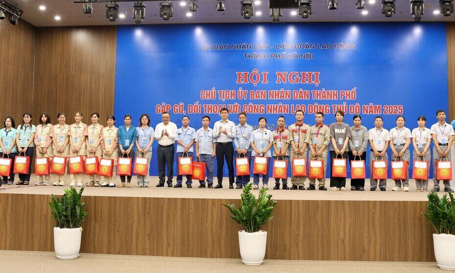 Los miembros y trabajadores sindicales son dificiles de recibir obsequios del presidente del comite pueblo de Hanoi, Tran Syh Thanh, y vicepresidente de VGCL Ngo Duy Hieu en la reunion y el dialogo. Foto: Manh Quan
