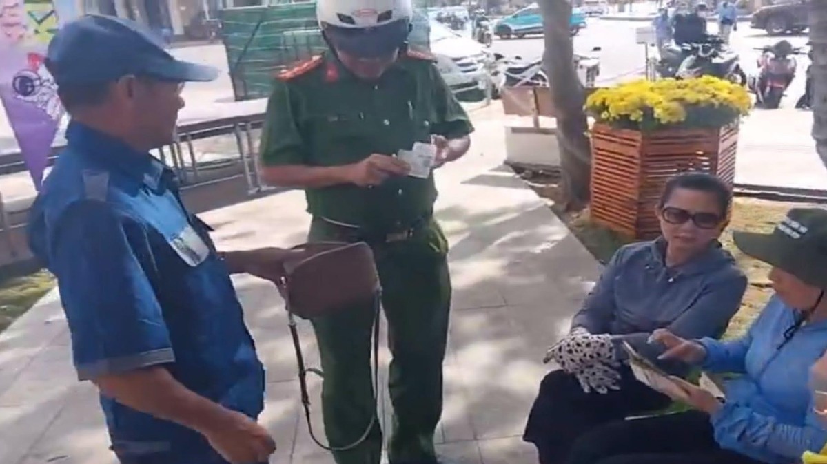 Worker L.T.A (left cover) handed over the property picked up in Bai Sau, Vung Tau City to the authorities. Photo: CACC