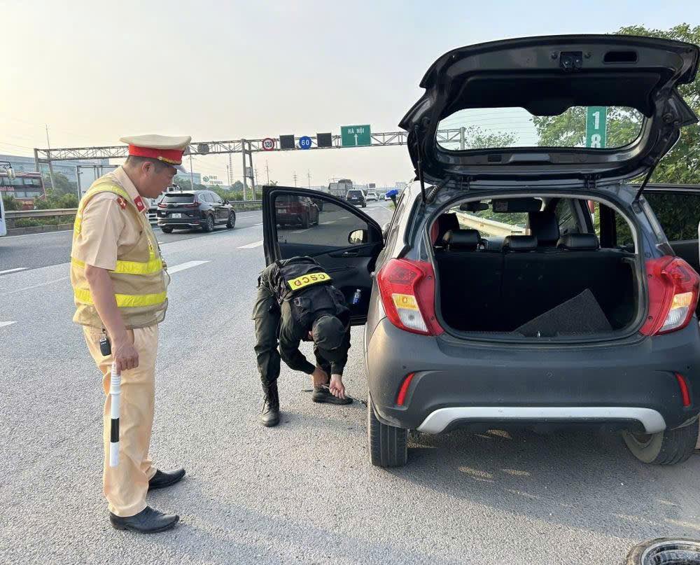 Police support people to help change tires on the highway. Photo: Nguyen Hung