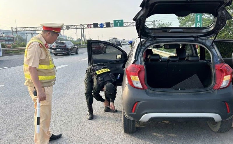 Police support people to help change tires on the highway. Photo: Nguyen Hung