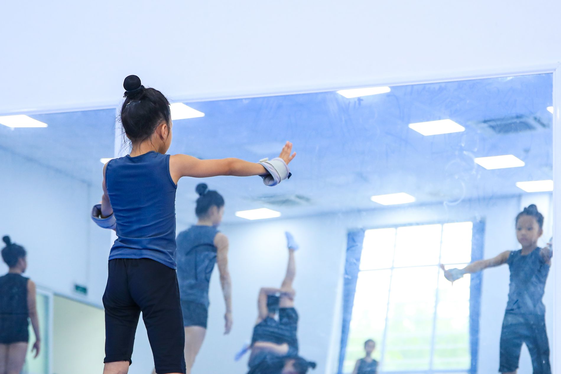 En el medio del entrenamiento aerobico, los atletas infantiles tendran un periodo de autostrante frente al espejo para ajustar el movimiento, uniformidad ... Foto: Minh Dan