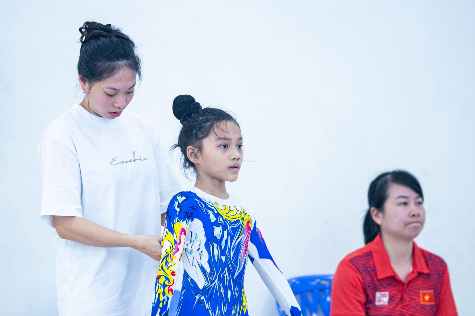 Huan luyen vien Ngoc Quynh ti mi chinh trang trang phuc cho hoc tro truoc buoi kiem tra. Anh: Minh Dan