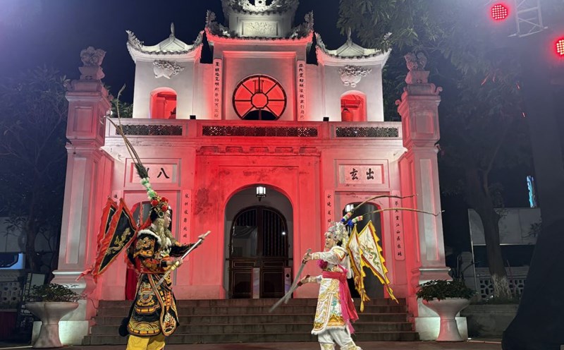 El artista meritorio y esposo del artista meritorio representa dos imagenes tipicas de Tuong - Dao Vo en el extracto de la obra "Vo Tam Tu", realizada en el Templo Quan Thanh en la gira nocturna. Foto: Pham Huyen