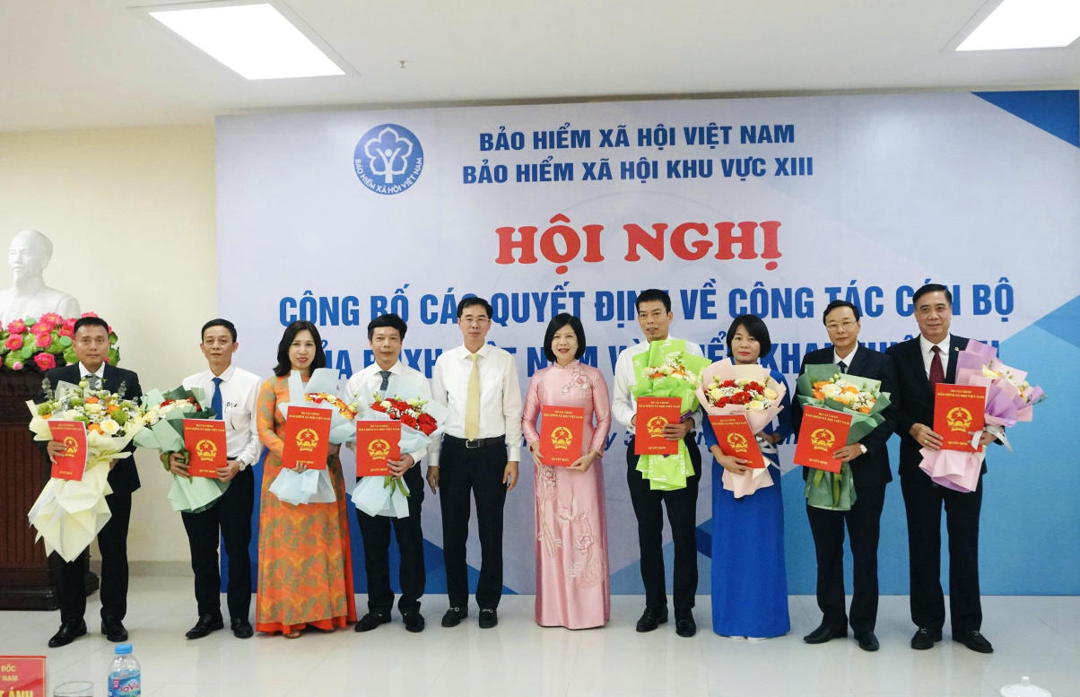Pho Giam doc BHXH Viet Nam Dao Viet Anh trao Quyet dinh va tang hoa chuc mung Ban lanh dao BHXH khu vuc XIII. Anh: BHXH tinh Hai Duong