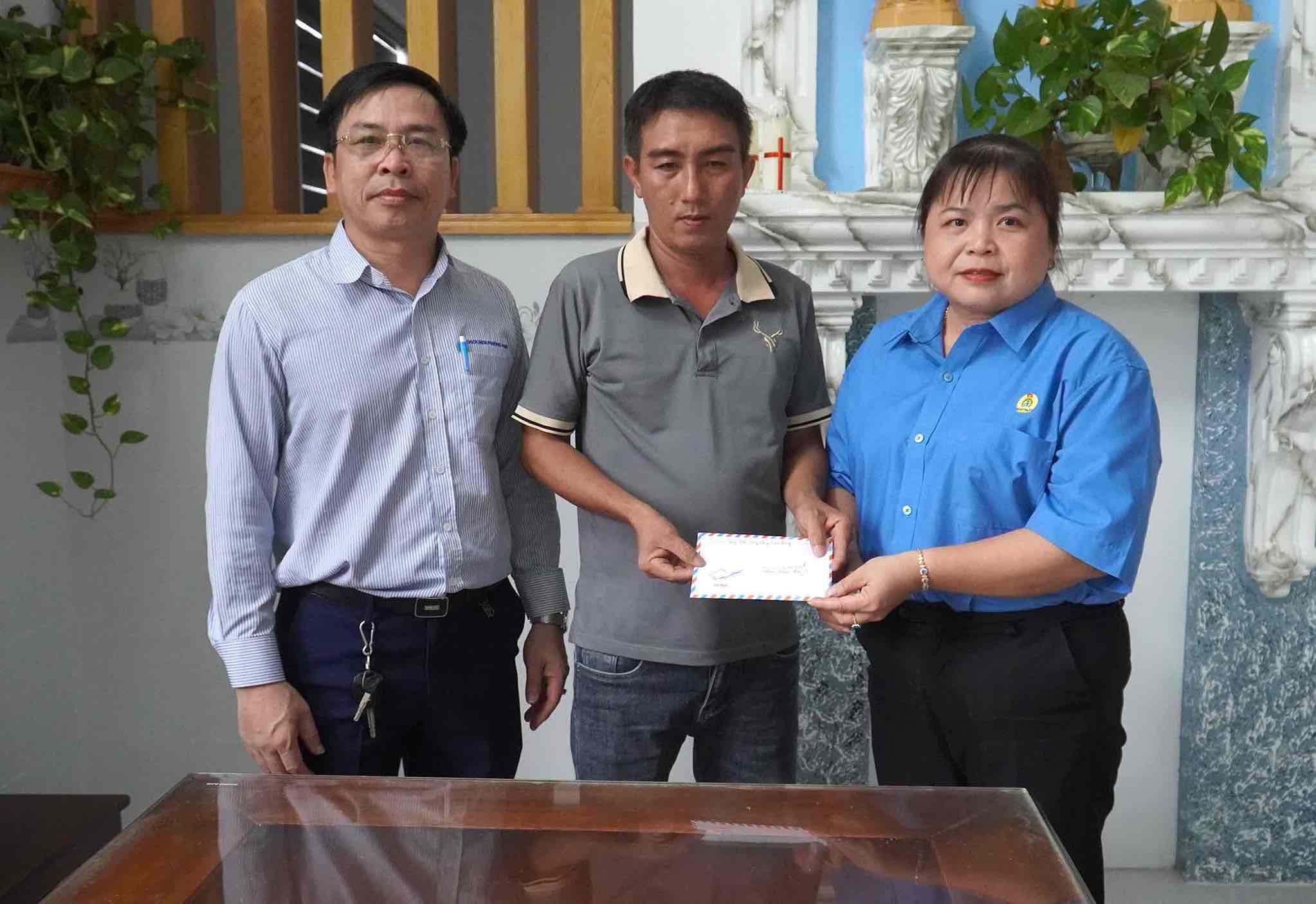 Chu tich LDLD huyen Vinh Cuu Nguyen Thi Minh Chau (ben phai anh), trao ho tro Quy XHTT Tam Long Vang cho cong nhan Dang Cao Hien. Anh: HAC