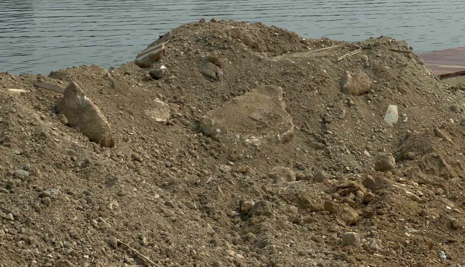 Màu đất đen sì, khác hẵn với đất đồi lấy từ mỏ. Quan sát có thể nhận thấy hàm lượng đất bùn, đất sét rất lớn. Ảnh: Phúc Đạt   