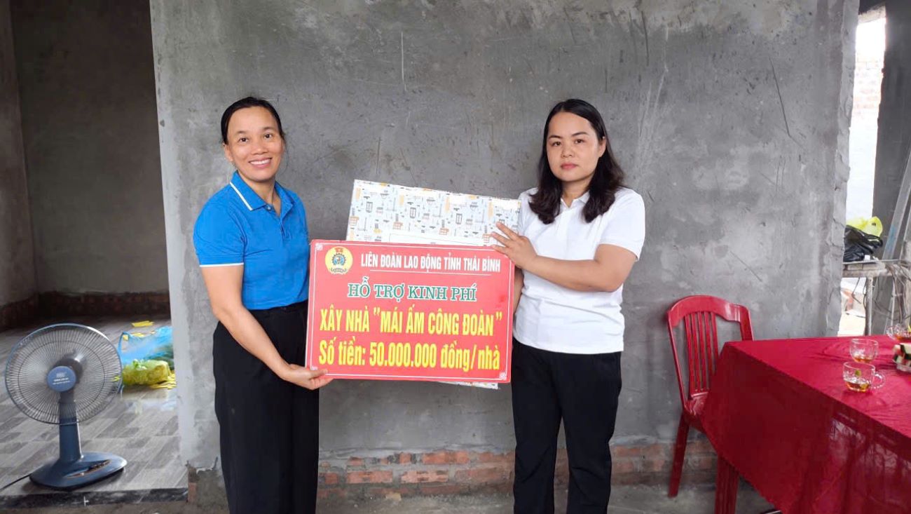 Phó Chủ tịch Liên đoàn Lao động tỉnh Thái Bình Phạm Thị Thắng trao quà và kinh phí hỗ trợ xây nhà cho đoàn viên Phạm Thị Dịu. Ảnh: Bá Mạnh