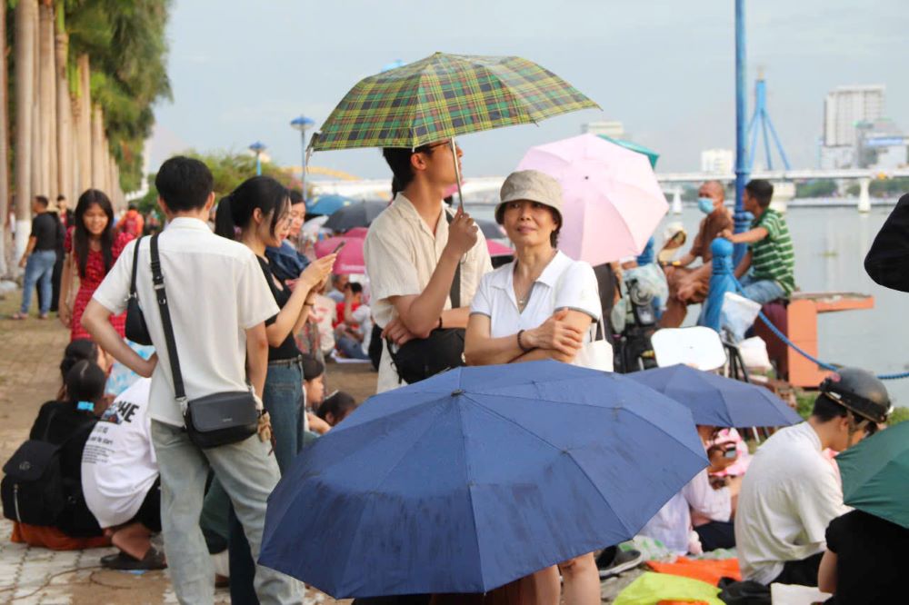 The sudden rain could not stop the flow of people flocking to Da Nang to watch the fireworks. Photo: Nguyen Linh
