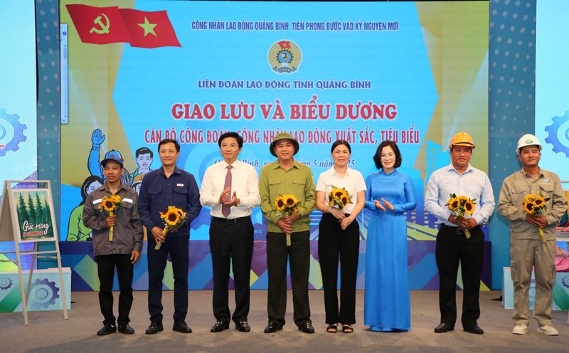 Mr. Truong An Ninh - Head of the Provincial Party Committee's Propaganda and Mass Mobilization Department and Ms. Dinh Thi Ngoc Lan - President of the Provincial Federation of Labor presented flowers to outstanding workers and union officials at the program. Photo: Cong Sang
