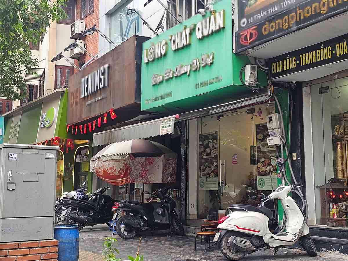 Paseo de la calle Tran Thai Tong (distrito de Cau Giay), donde muchos empleados de un local de cigarrillos hacen cola para medir la longitud de los cigarrillos. Imagen de la derecha