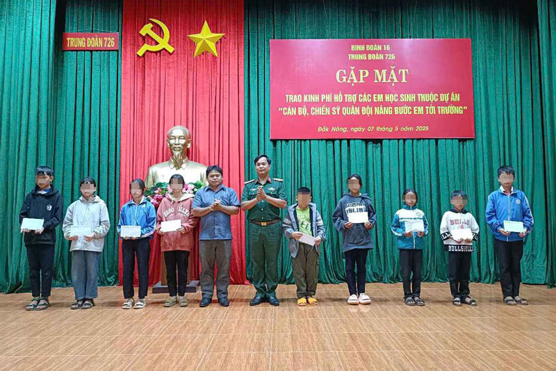  Trung tá Đỗ Văn Tráng - Chính ủy Trung đoàn 726 cùng chính quyền xã Quảng Trực trao kinh phí tặng các em học sinh. Ảnh: Hồng Thắm