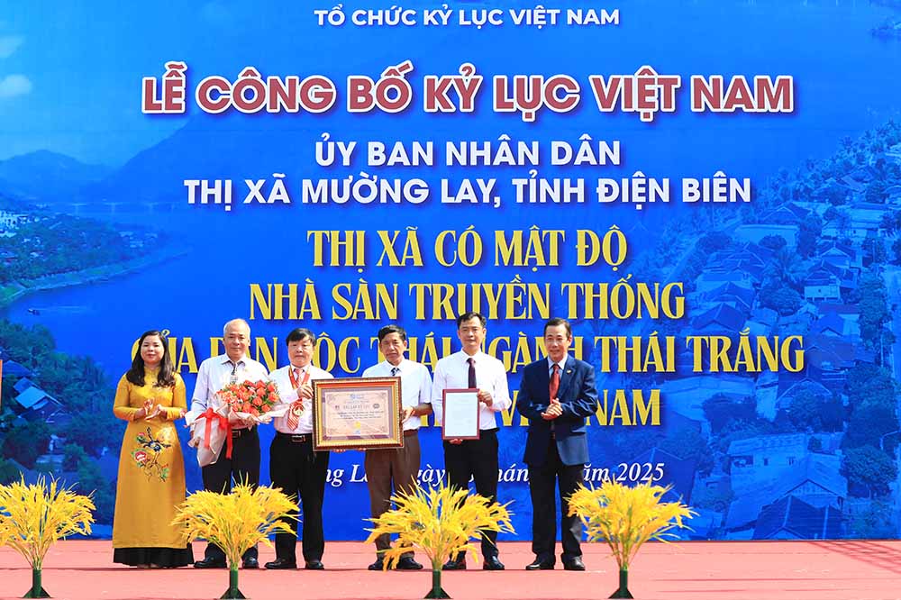 Dai dien To chuc Ky luc Viet Nam trao xac lap ky luc Viet Nam “Thi xa co mat do nha san truyen thong cua dan toc Thai nganh Thai trang nhieu nhat Viet Nam” cho thi xa Muong Lay. Anh: Quoc Quan