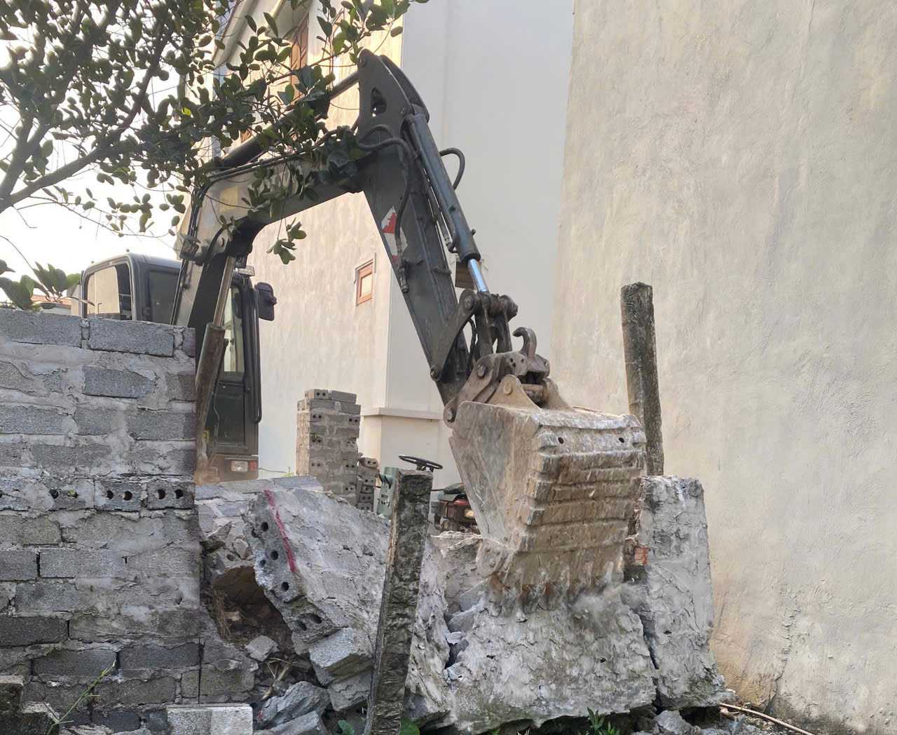 The People's Committee of Ninh An commune mobilized machinery and human resources to demolish the surrounding walls and reopen the path for families. Photo: Nguyen Truong