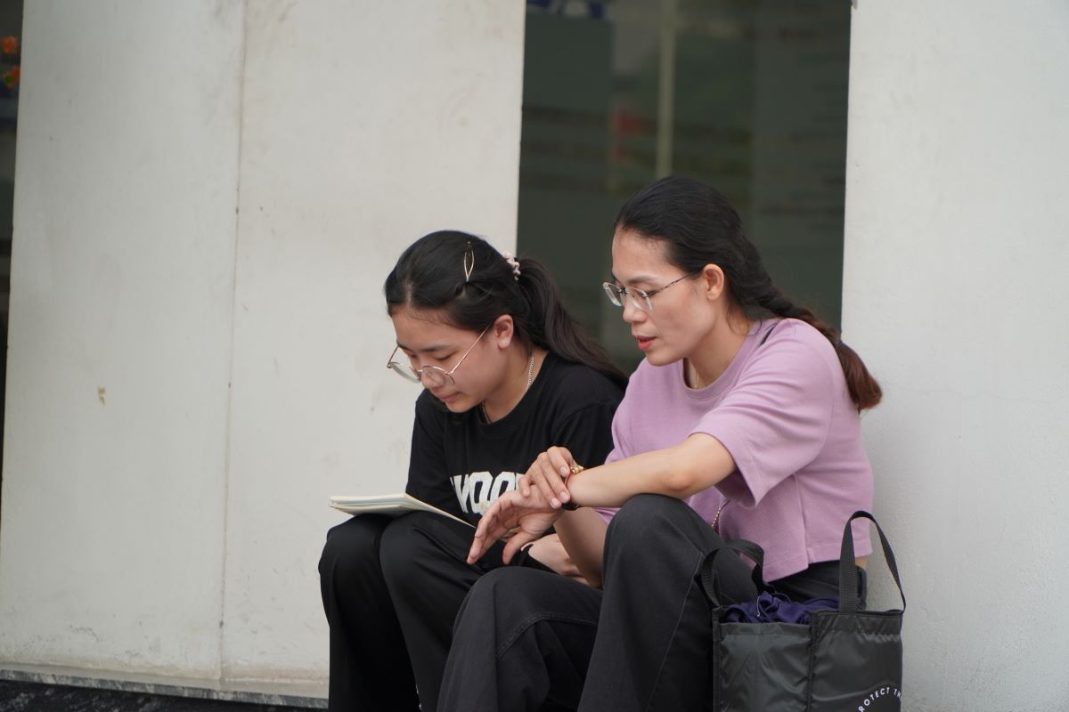 Thí sinh đến điểm thi từ sớm, kiểm tra kỹ thông tin và tranh thủ ôn lại bài. Ảnh: Anh Đức