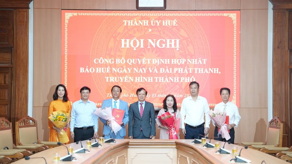 Lanh dao TP Hue trao quyet dinh bo nhiem va tang hoa chuc mung Ban Giam doc Trung tam Truyen thong thanh pho sau hop nhat. Anh: Duc Quang.