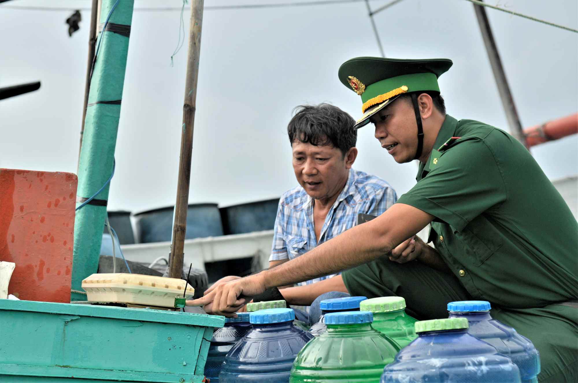 Officers of Kinh Dai Control Station check the stamp and sealing lead of the black box mounted on the offshore fishing boat. Photo: Tien Vinh
