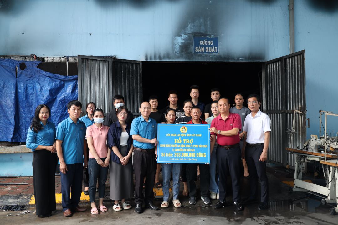 Ong Le Duc Tho – Pho Chu tich Lien doan Lao dong tinh trao ho tro kinh phi cho doanh nghiep, nguoi lao dong Cong ty Co phan may Nam Chau. Anh: Quyet Chien
