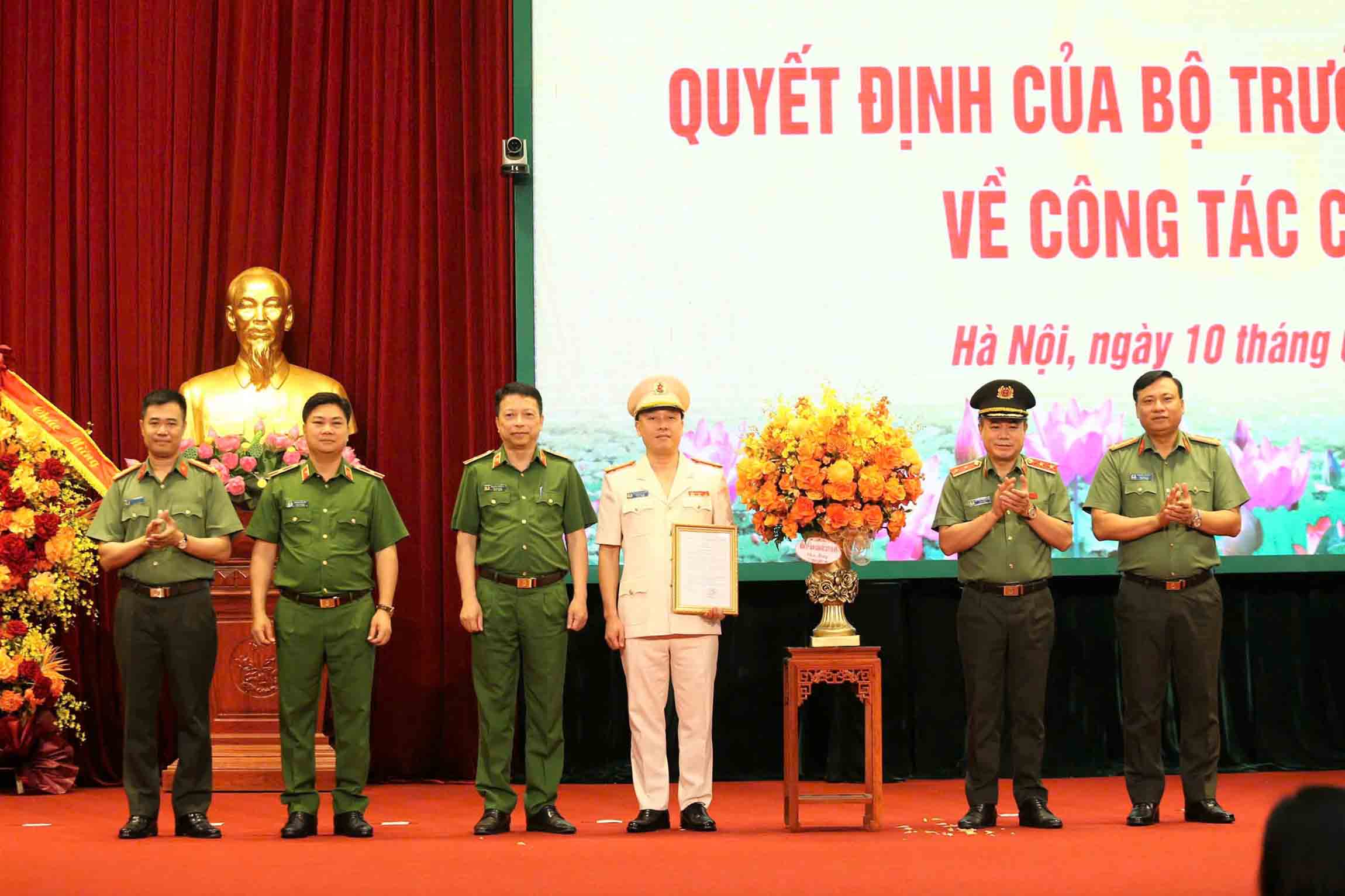 Lieutenant General Nguyen Thanh Tung, Director of Hanoi Police, presented the Decision and presented flowers to congratulate the new Deputy Director, Colonel Nguyen Duc Long. Photo: Hanoi Police