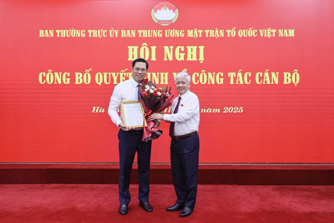 El presidente del Comite Central del Frente de Patria de Vietnam, Do Van Chien, otorgo la decision, dio flores para felicitar al Sr. Bui Duy Dong. Foto: Quang Vinh