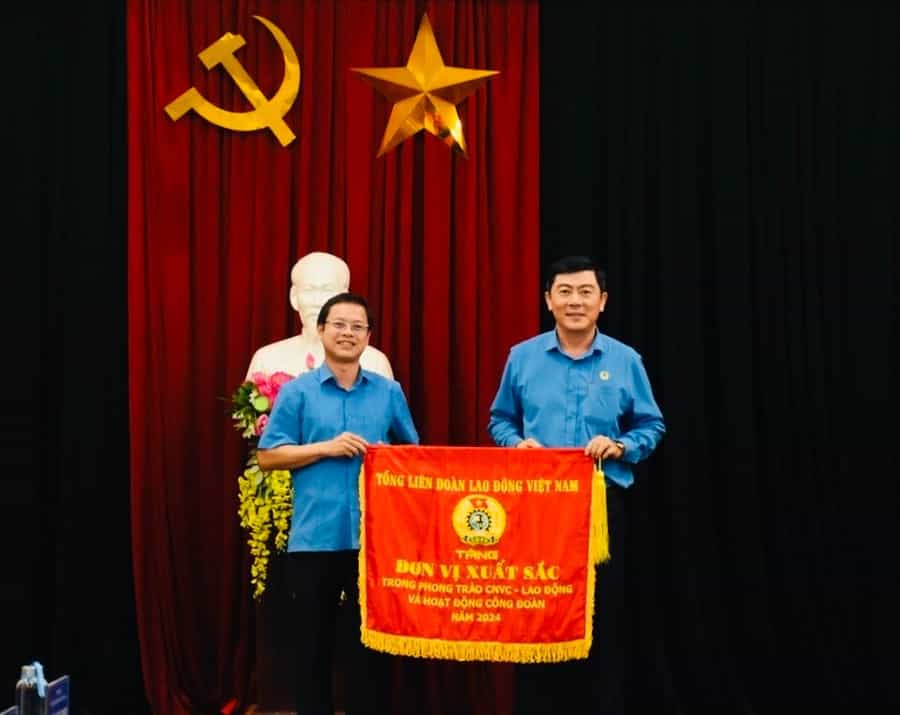 Mr. Nguyen Hoang Phong (left cover) - Chairman of the Gia Lai Provincial Federation of Labor presented the Emulation Flag of the Vietnam General Confederation of Labor to the Duc Co District Federation of Labor. Photo: Thanh Tuan