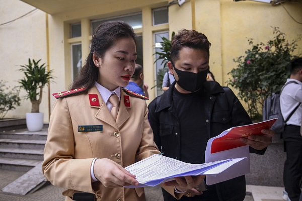 Traffic police guide people to change their driving licenses. Photo: Duc Anh