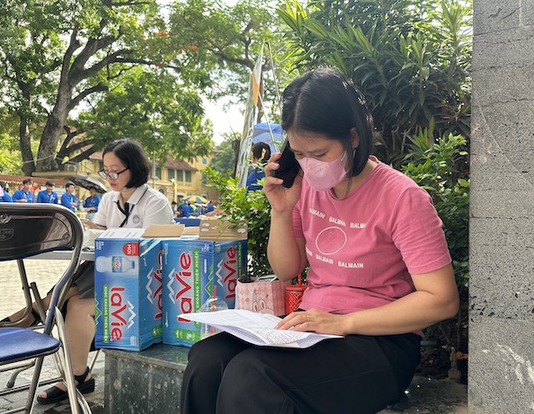 Co giao Le Thi Thanh Tuyen - Trung tam Giao duc nghe nghiep, Giao duc Thuong xuyen Tay Ho - dang goi dien cho nguoi nha cac thi sinh chua co mat tai diem thi. Anh: Anh Duc