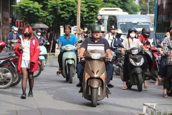 Motorbikes climb the sidewalk to move quickly during rush hour in Hanoi. Photo: Nguyen Linh