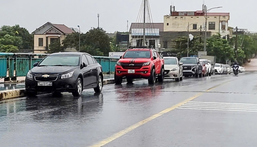 Nguoi dan o thi xa Quang Tri dua xe len cau de tranh nuoc lu.