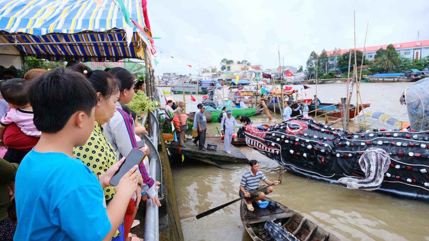 Nguoi dan hao huc xem thuyen hoa va cac mo hinh dong vat dieu hanh tren song. Anh: My Ly