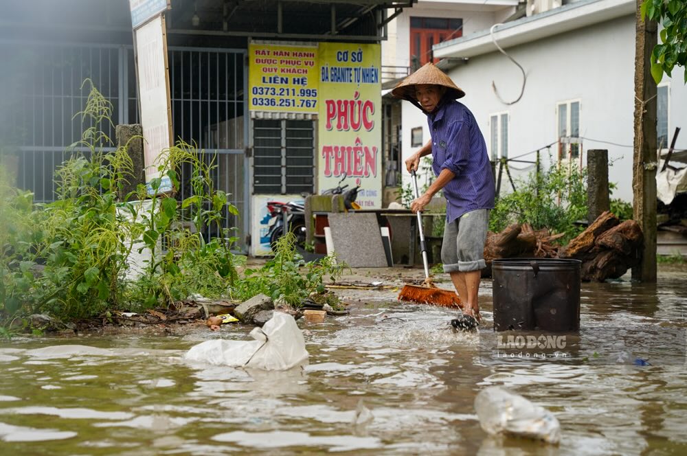 Dong nuoc lon cuon theo nhieu rac thai, buoc nguoi dan phai lien tuc don dep.