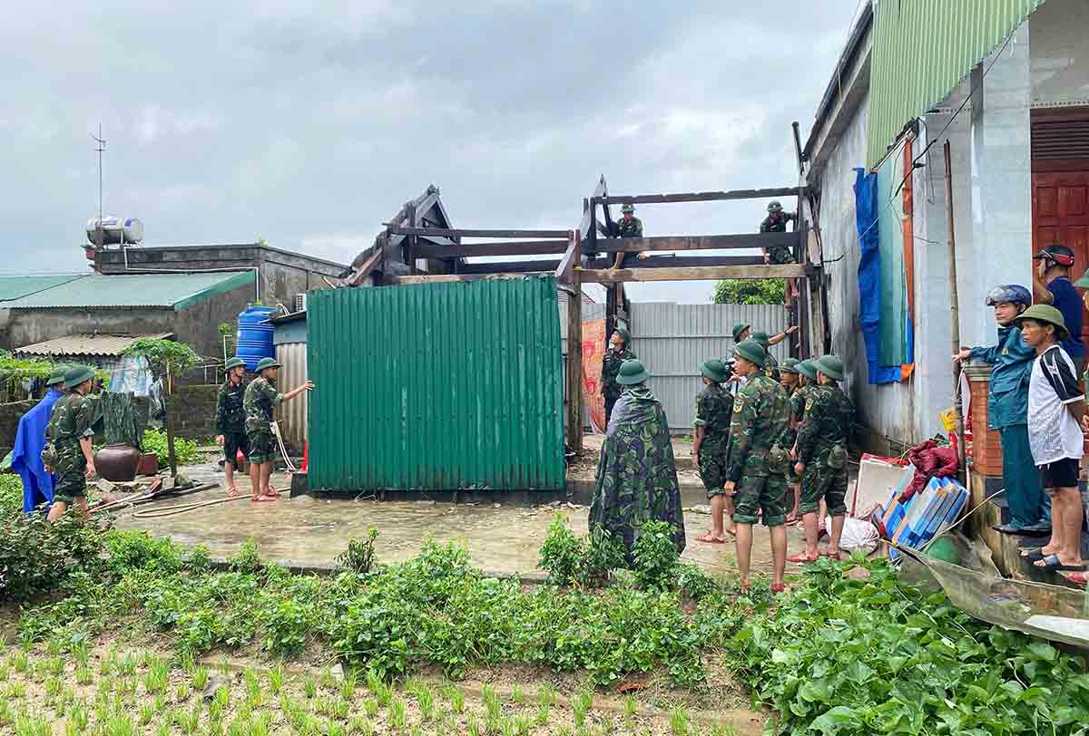 Bo doi dang sua lai ngoi nha go bi toc mai. Anh: Tran Tuan.