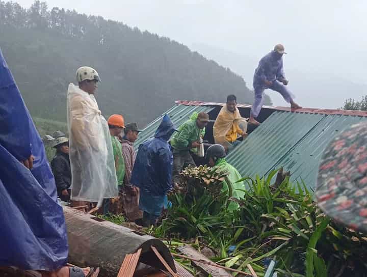 Under heavy rain, people joined hands to repair damaged and blown off the roofs. Photo: Thanh Tuan