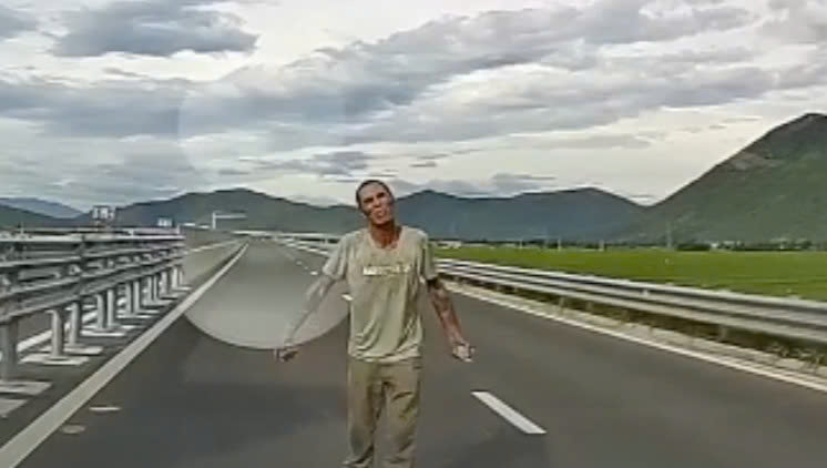 Người dân quay lại sự việc người đàn ông cầm đá chặn xe trên cao tốc Vân Phong - Nha Trang. Ảnh: Hữu Long