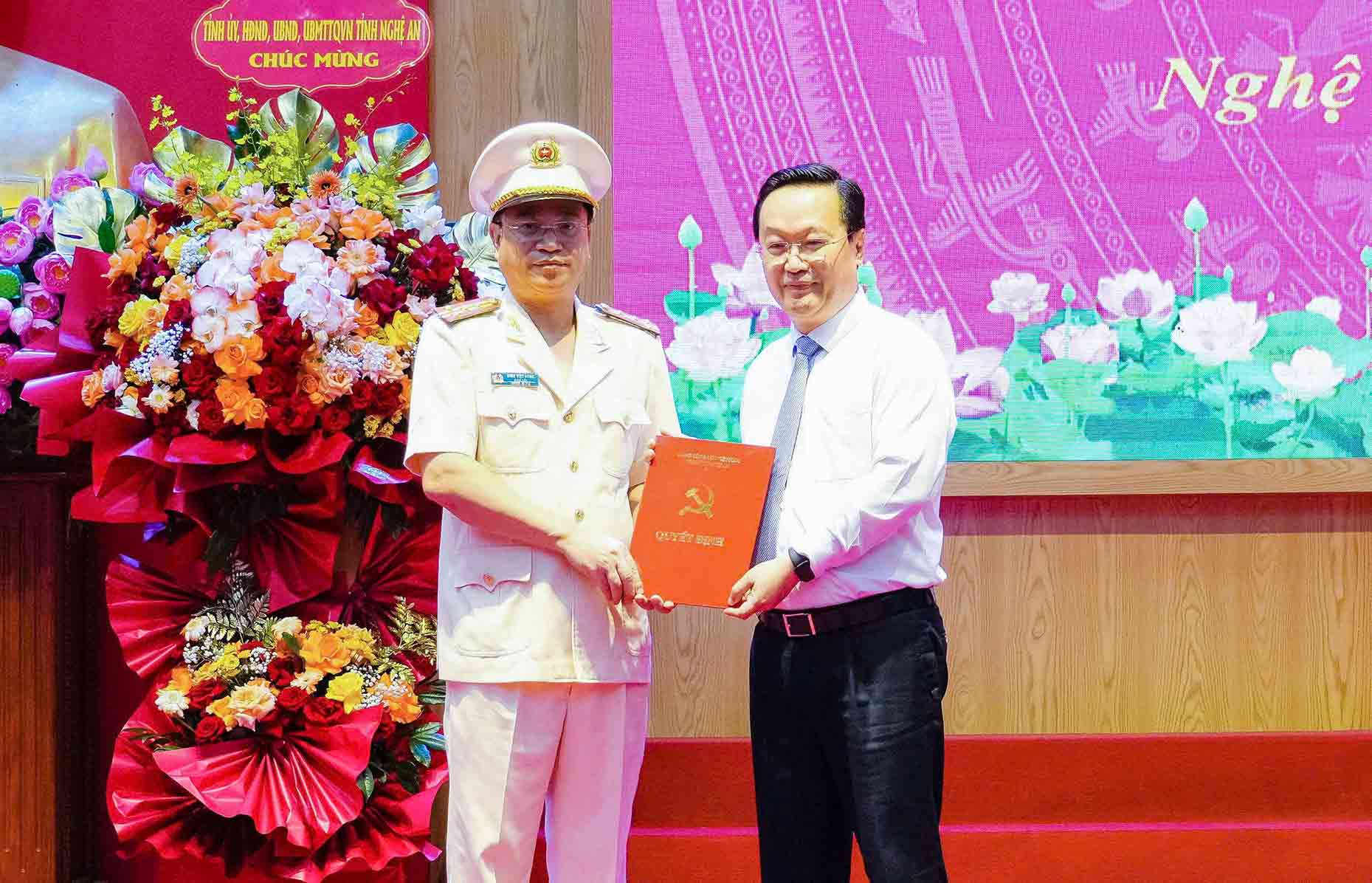 Ong Nguyen Duc Trung - Bi thu Tinh uy Nghe An trao quyet dinh, tang hoa chuc mung Dai ta Dinh Viet Dung - Bi thu Dang uy, Giam doc Cong an tinh. Anh: Hai Dang