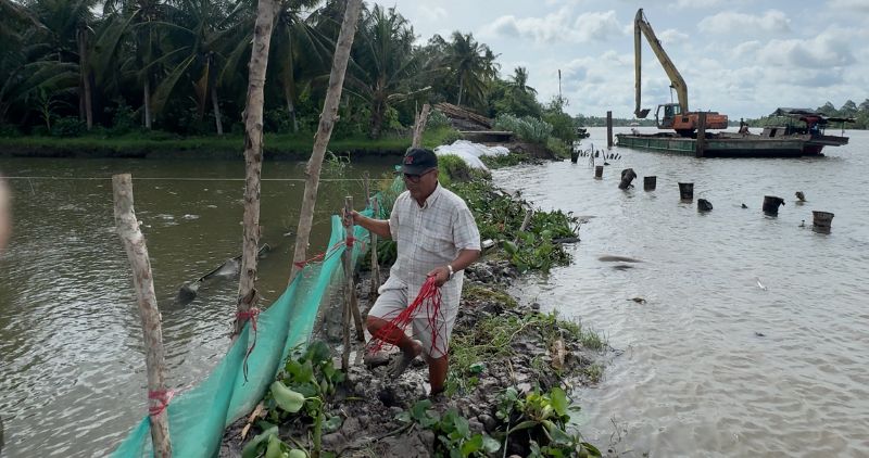 People temporarily reinforce the landslide dike along Mang Thit River. Photo: Hoang Loc