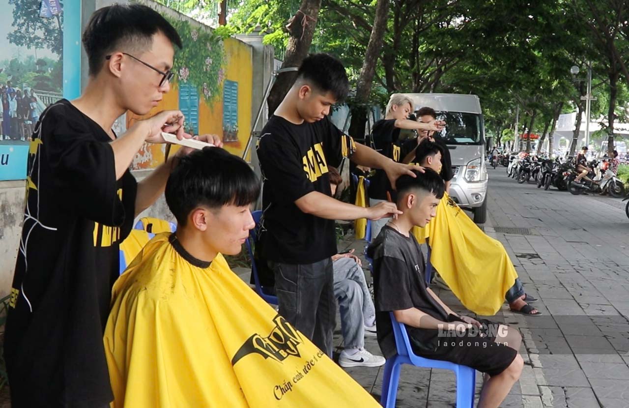Cac ban tre hot toc mien phi cho nguoi dan tren duong Pham Van Dong (phuong Mai Dich, quan Cau Giay, TP Ha Noi). Anh: Thanh Nhan