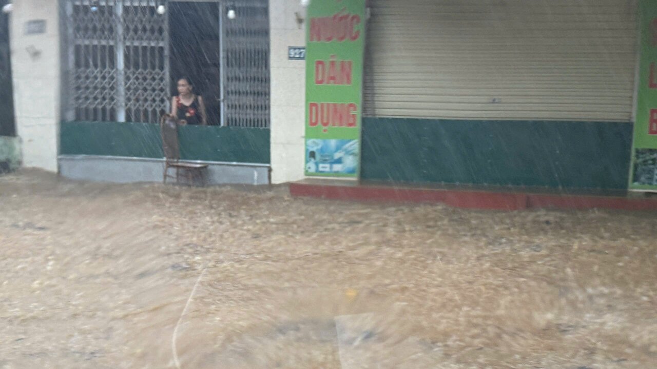 Nguoi dan dung cac vat dung chan nuoc tran vao nha.