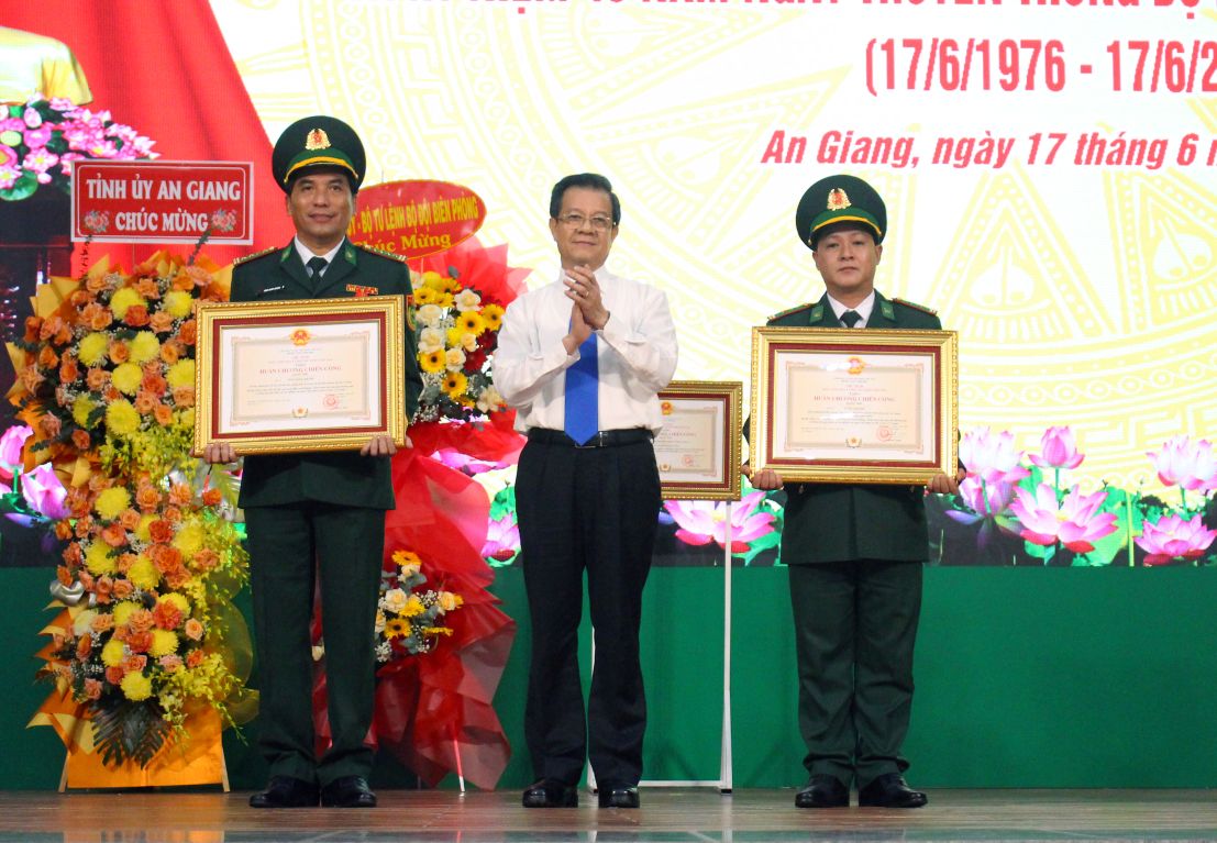 Thua uy quyen Chu tich nuoc, Bi thu Tinh uy An Giang Le Hong Quang trao Huan chuong Chien cong hang Nhi cho Dai ta Nguyen Quoc Khanh va Trung ta Vo Huy Hoang. Anh: Luc Tung