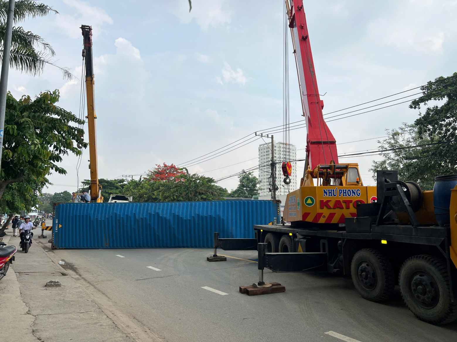 The tractor-trailer overturned, the container fell and hit the motorbike. Photo: Dinh Trong