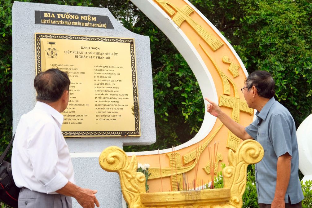 Nha bao Truong Thanh Nha va nha bao Ngo Hoang Van (tu trai sang) xuc dong khi xem lai Bia tuong niem can bo Tuyen huan, thong tan bao chi hy sinh trong chien tranh bi that lac phan mo tai Nghia trang huyen Vinh Thuan. Anh: Phong Linh
