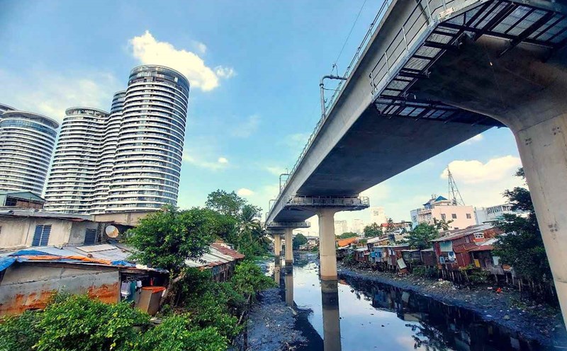 A row of dilapidated houses along Van Thanh canal, next to which are the high-rise and elevated sections of Metro Line 1 of Ho Chi Minh City running through. Photo: Minh Quan
